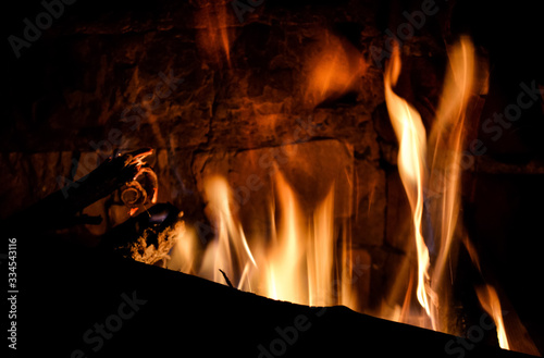 Closeup photo of blazing and warming fireplace in the cold evening.