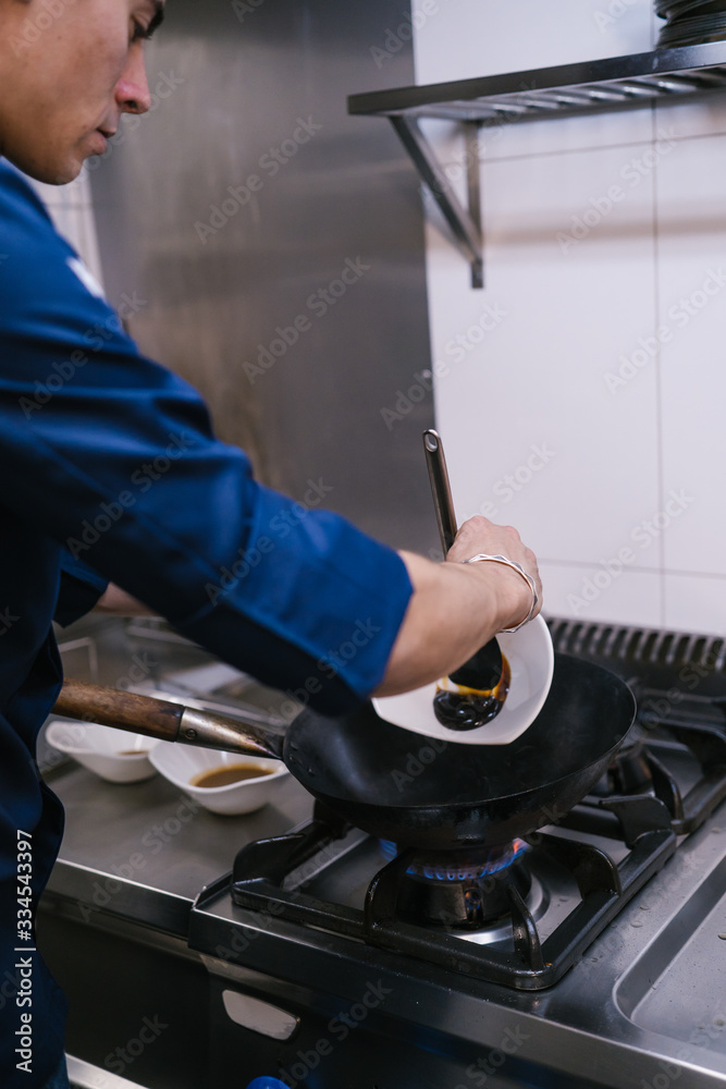Young chef cooking in a modern restaurant kitchen Young chef cooking in a modern restaurant kitchen