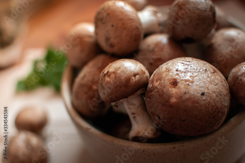 Close-up of brown mushrooms in a bowl, on wooden table