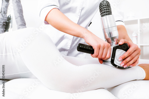 Lymphatic drainage body massage. Vacuum foot massage. A patient in a white suit in the cosmetologist's office on the procedure of LPG massage.