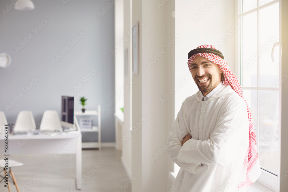 Arab man stands in a white office.
