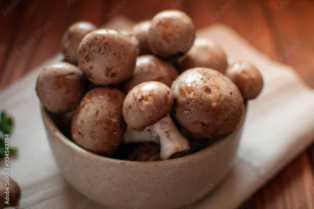 Close-up of brown mushrooms in a bowl, on wooden table Close-up of brown mushrooms in a bowl, on wooden table