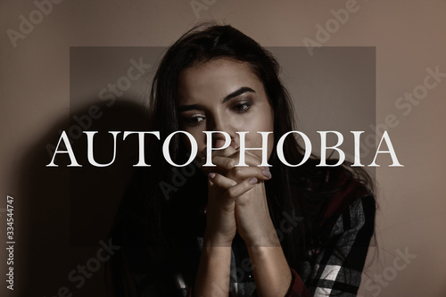 Depressed young woman near brown wall. Autophobia photo