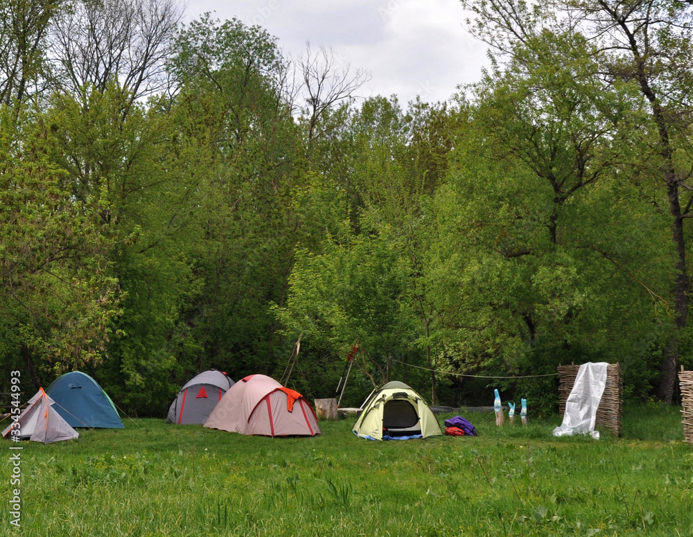 Tents near the forest, in summer people rest in a tent camp, trekking Tents near the forest, in summer people rest in a tent camp, trekking