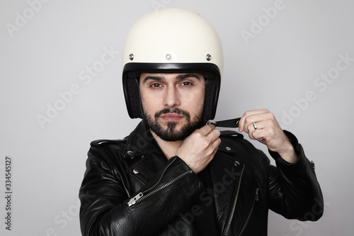 Close-up portrait of young happy biker man with white cafe-racer helmet. White background.