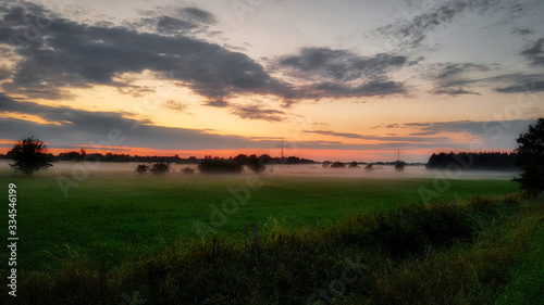 Misty fields in a sunset scene in northern germany in early summer