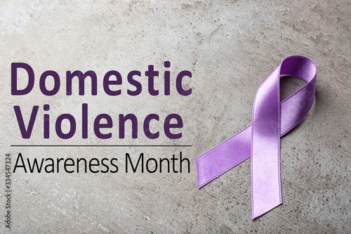 Purple ribbon on grey background. Symbol of Domestic Violence Awareness photo