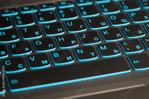 Close-up of laptop keyboard backlight, blue backlit keyboard. photo