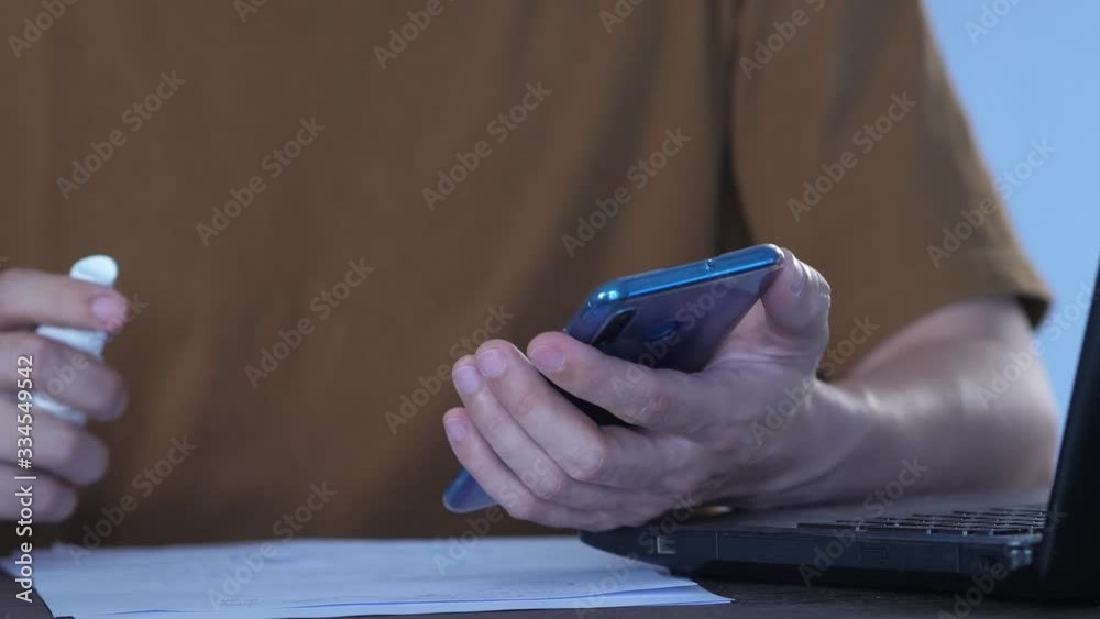spary alcohol to object, disinfecting of smartphone screen surface for preventing the spread of coronavirus. Antiseptic alcohol wipes. Disinfection Efforts Against Coronavirus
