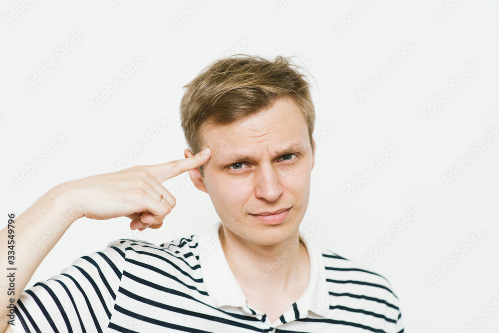 Closeup portrait of angry man gesturing with his finger against his temple, are you crazy? Closeup portrait of angry man gesturing with his finger against his temple, are you crazy?
