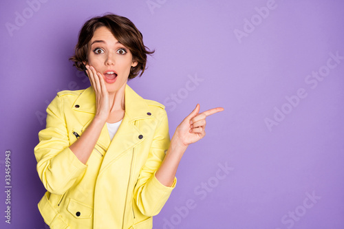 Portrait of astonished funky girl present incredible ads promotion impressed touch hand face scream wow omg wear good look clothes isolated over violet color background photo