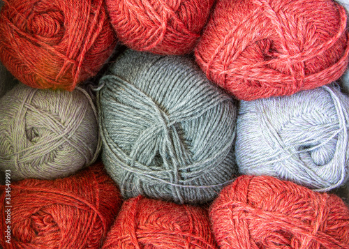 Grey and red balls of different woolen yarn