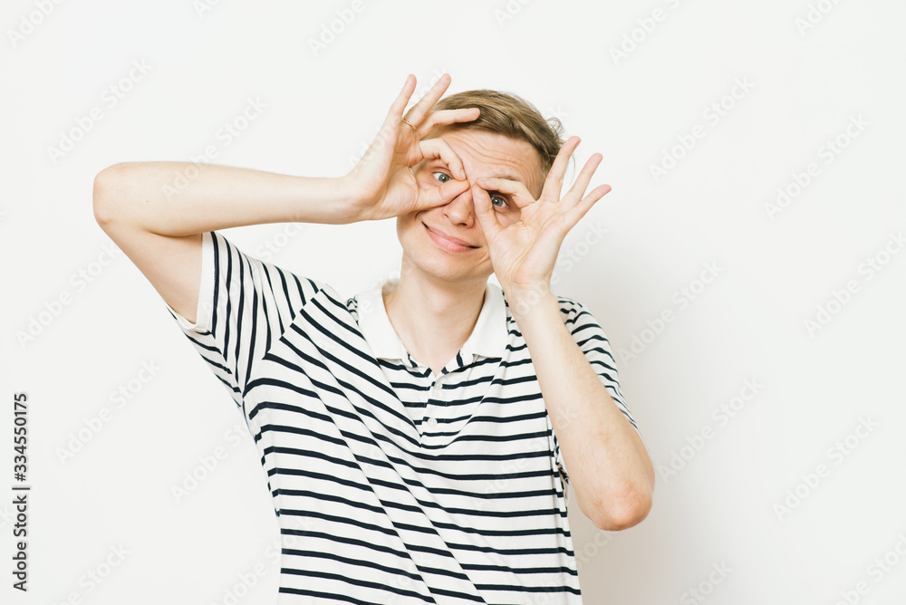 man looking through hands, making binoculars