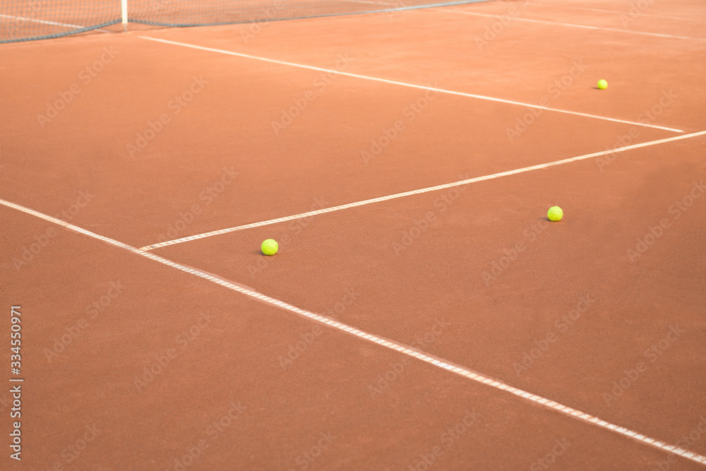 Balls, lines and net on a clay tennis court where no match is played