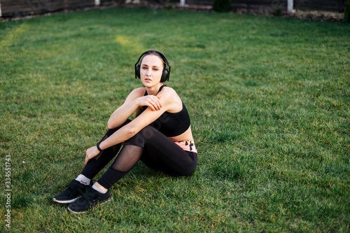 Young sporty woman sits on the lawn © Vadim Pastuh