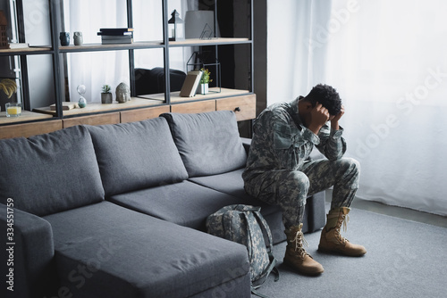 African American soldier in military uniform suffering from PTSD at home © LIGHTFIELD STUDIOS