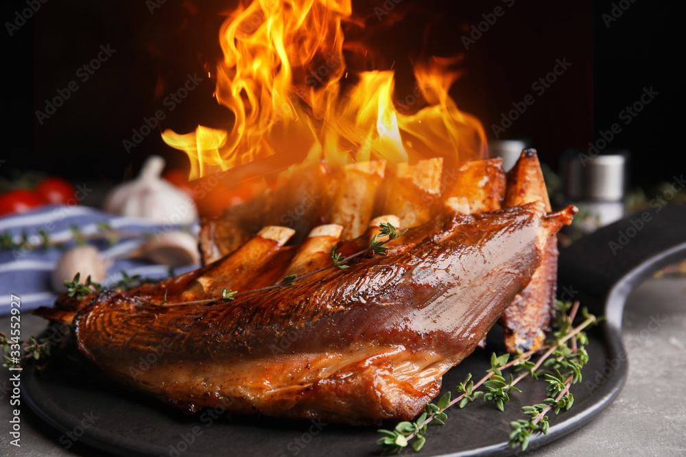 Delicious roasted ribs with flame on table Delicious roasted ribs with flame on table