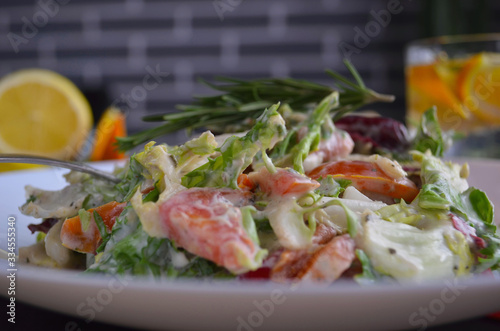 Salad with radishes, lettuce and cherry tomatoes seasoned with diet yogurt. Vitamin spring salad of fresh vegetables. Top view and side view.