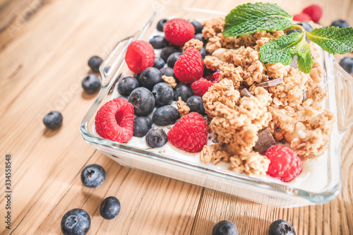 Breakfast of granola and wild berries. Delivered in a glass plate