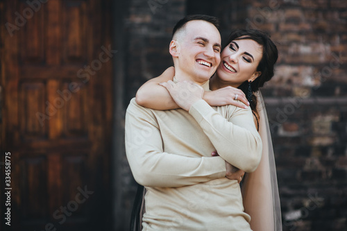 Stylish man and cute girl hug and laugh. Wedding portrait of lovers newlyweds. Fun photo, concept.