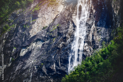 Panoramic beautiful deep forest waterfall in norway near blue ocean. Waterfalls mountain view close up.