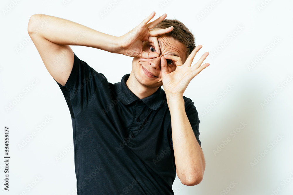 man looking through hands, making binoculars man looking through hands, making binoculars