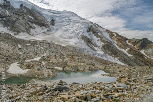 Small lake on Hohsaas with beautifull views on Trift glacier in Swiss Alps photo