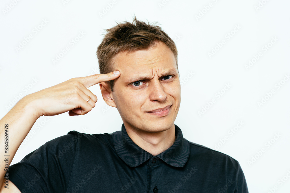 Closeup portrait of angry man gesturing with his finger against his temple, are you crazy? Closeup portrait of angry man gesturing with his finger against his temple, are you crazy?
