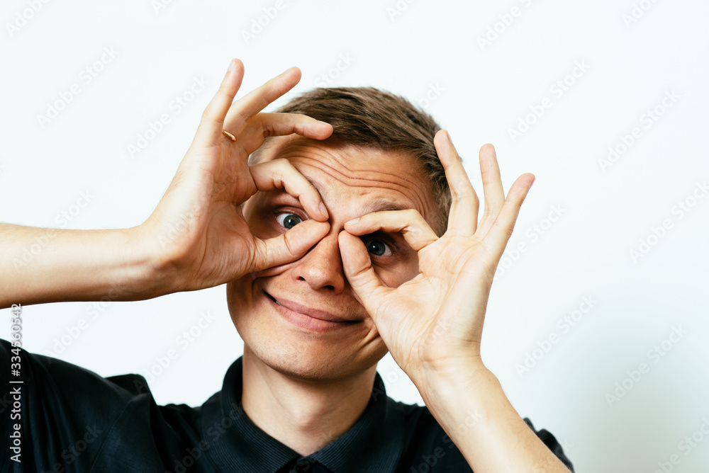 man looking through hands, making binoculars man looking through hands, making binoculars