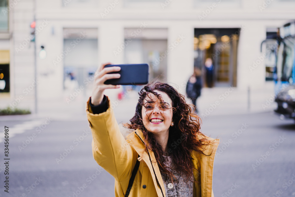 young beautiful tourist woman taking a selfie outdoors in the street. Happy woman smiling. lifestyle and travel concept