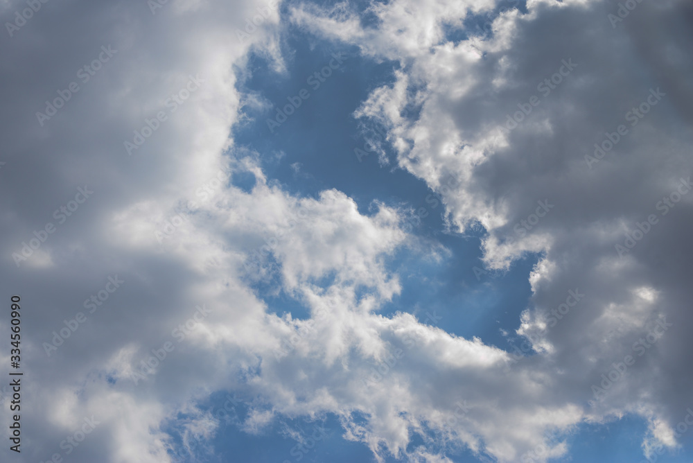 Fototapeta premium Thick gray clouds with white edges on a blue sky.