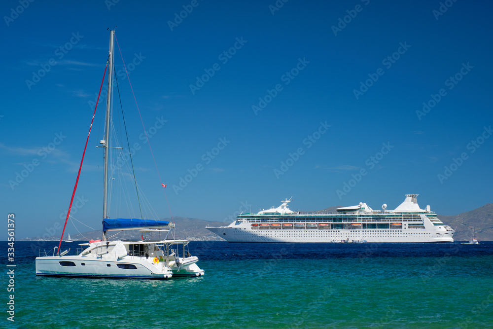 Fototapeta premium Catamaran yacht and cruise liner is Aegean sea on beautiful summer day. Chora, Mykonos island, Greece