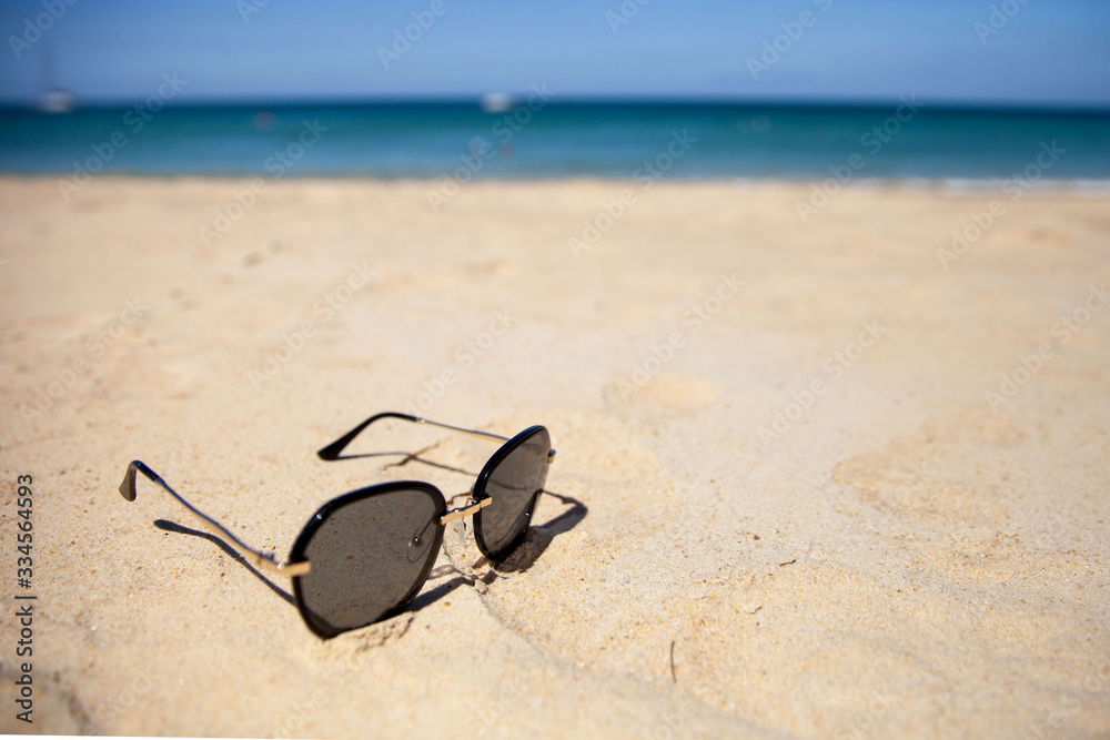 sunglasses with on the sand on a Sunny summer beach. sunglasses with on the sand on a Sunny summer beach.
