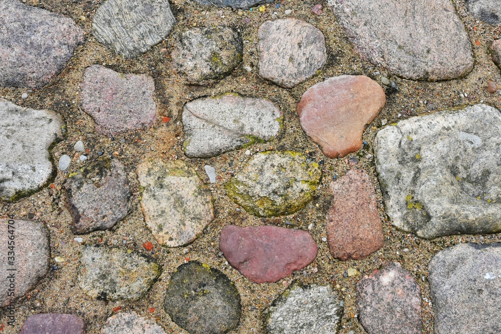 Colorful natural stone pathway. Ancient stone surface with different bricks and sand. Abstract background . Colorful natural stone pathway. Ancient stone surface with different bricks and sand. Abstract background .