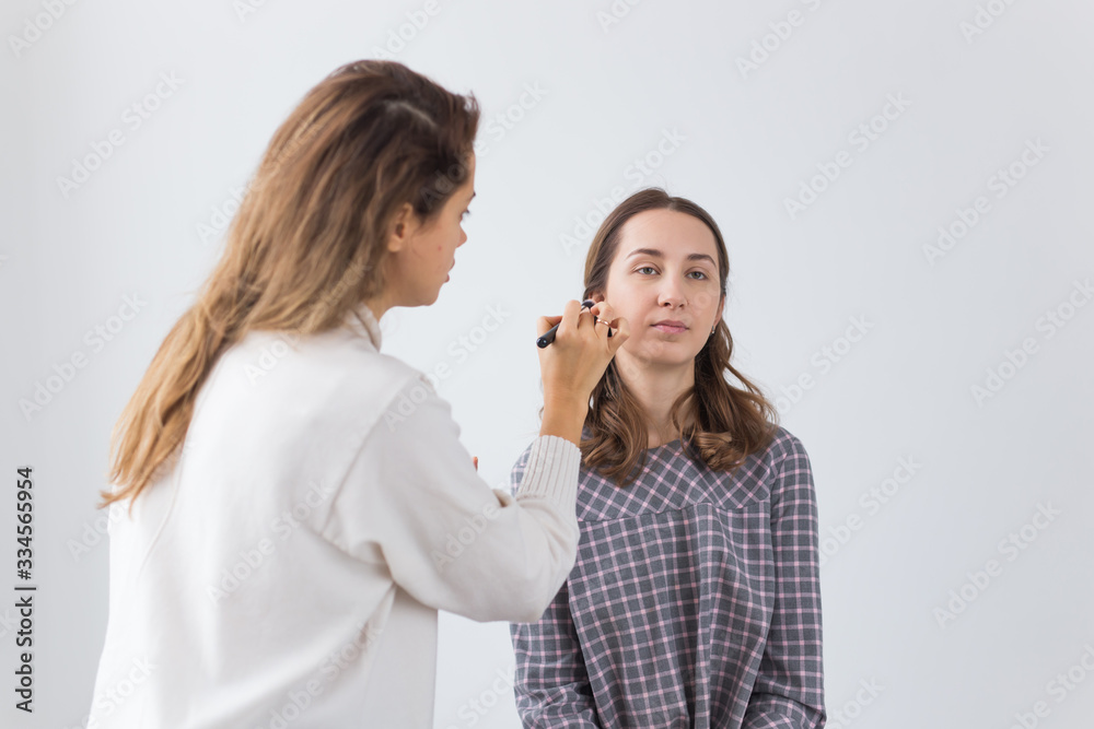 Beauty and cosmetics concept - Makeup artist doing professional make up of young woman Beauty and cosmetics concept - Makeup artist doing professional make up of young woman