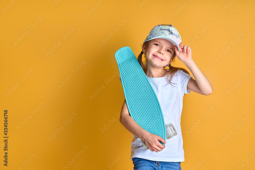 Active and happy. Kid having fun with penny board. Child smiling face stand skateboard. Penny board cute skateboard for girls. Lets ride. Girl ride penny board yellow background. Summer vacation.