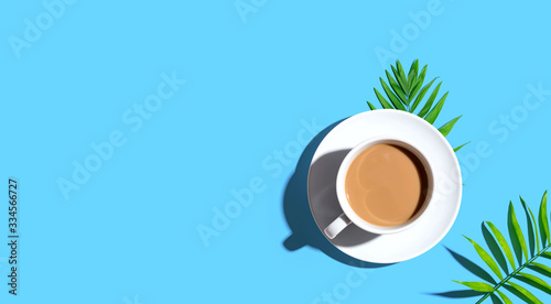 A cup of coffee with tropical leaves - flat lay