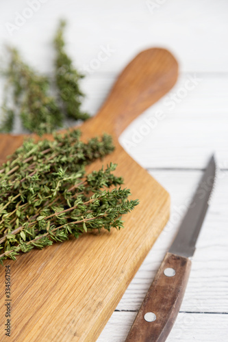 Close up thyme on board at white background with knife