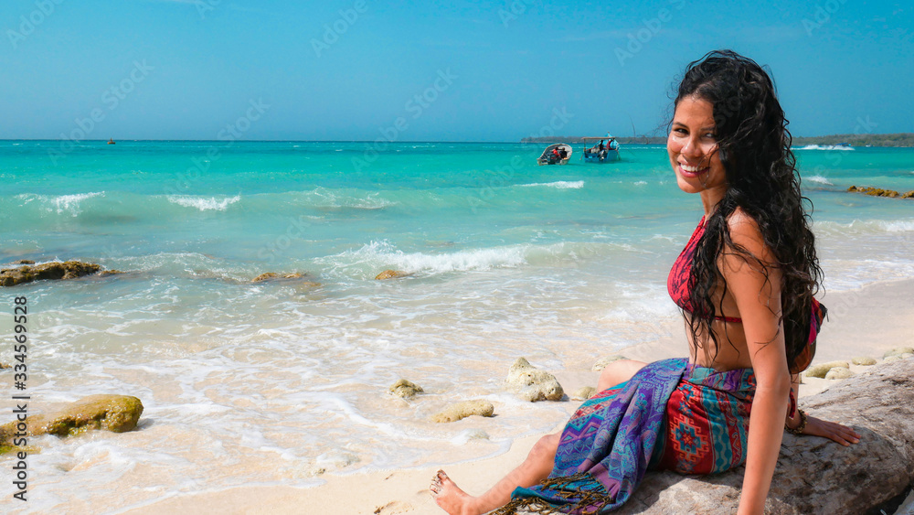 Beautiful happy latin woman relaxing at the beach with turquoise waters. Positive human emotion. Free happy girl enjoying nature. Beautiful happy latin woman relaxing at the beach with turquoise waters. Positive human emotion. Free happy girl enjoying nature.