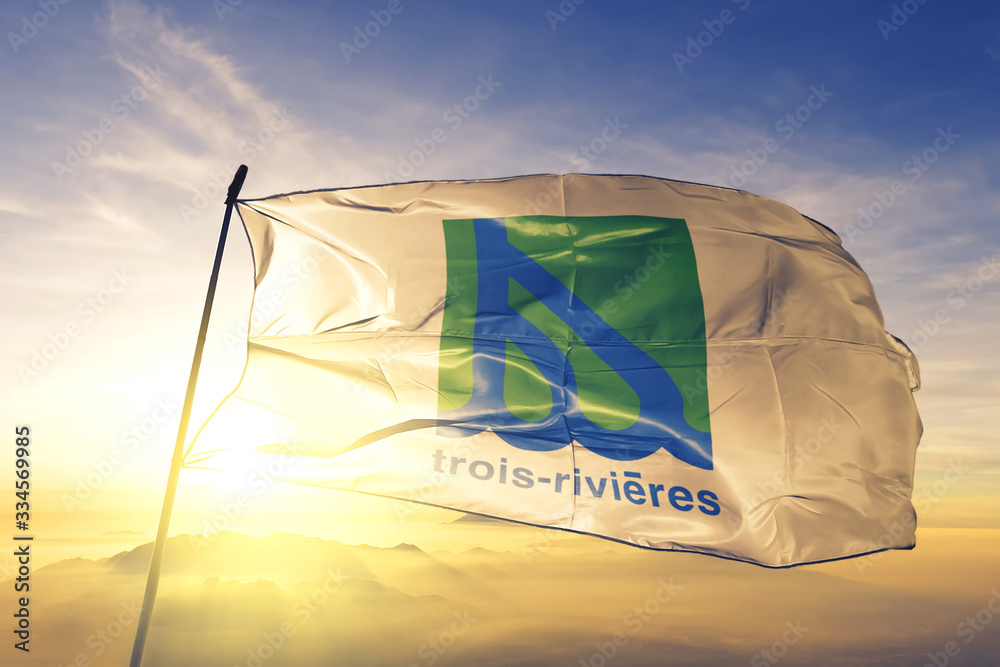 Trois-Rivieres of Quebec of Canada flag waving on the top sunrise mist fog