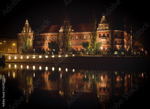 National Museum of Wroclaw shoted in the evening and its reflection in Odra river