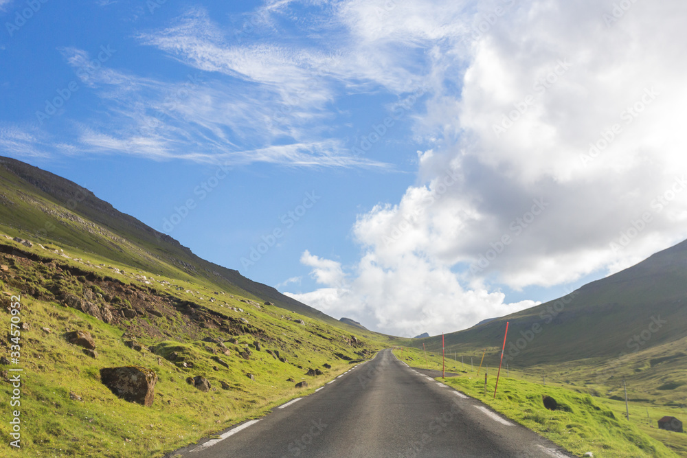 Road running through green valleys of Faroe Islands