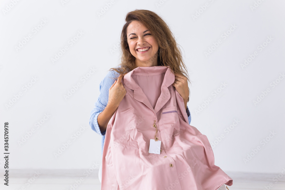 Online shopping, delivery and fashion concept - Woman sitting on sofa at home opening online clothing purchase Online shopping, delivery and fashion concept - Woman sitting on sofa at home opening online clothing purchase