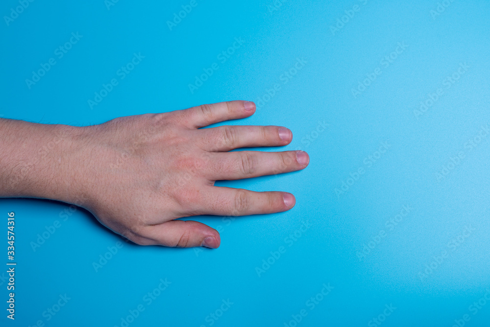 male hand on a blue background, close-up
