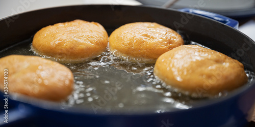 Φωτογραφία Home made doughnuts frying in oil
