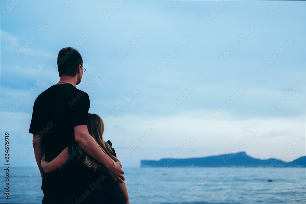Father with daughter near river at sunset. Dad and kid holding hands and watching sunrise together. Happy man and child relaxing on beach, family enjoying beautiful view. Bonding and togetherness Father with daughter near river at sunset. Dad and kid holding hands and watching sunrise together. Happy man and child relaxing on beach, family enjoying beautiful view. Bonding and togetherness