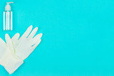 White latex gloves and hand sanitizer gel on blue background. Coronavirus protection. Top view. Flat lay. Copy space for text