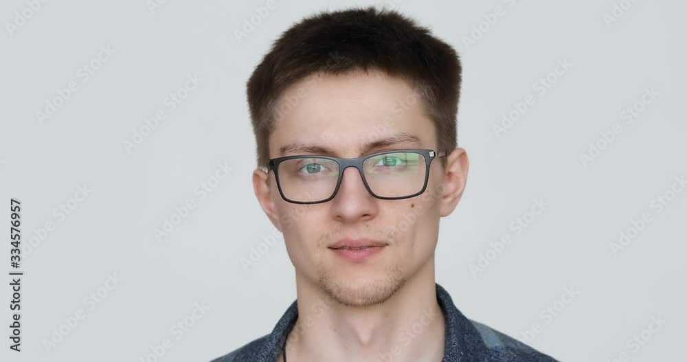 portrait of a guy with glasses who grimaces at the camera on a white background portrait of a guy with glasses who grimaces at the camera on a white background