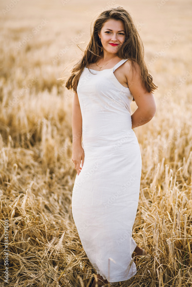 beautiful girl with brunette hair on a wheat field background. warm summer time. beautiful girl with brunette hair on a wheat field background. warm summer time.