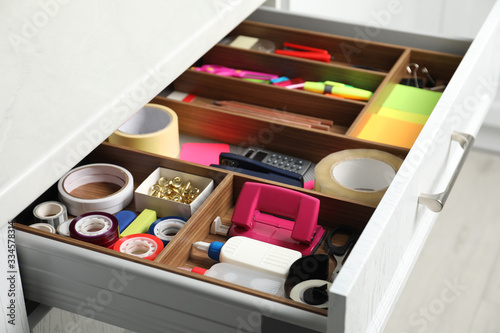 Photo Different stationery in open desk drawer indoors